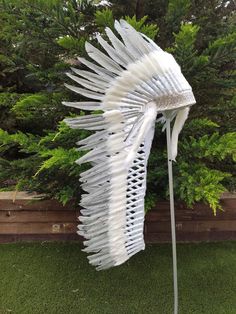 a white sculpture sitting on top of a lush green field