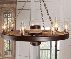 a wooden chandelier with glass jars and lights hanging from it's center