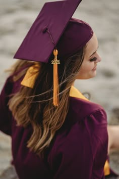 a woman wearing a purple graduation cap and gown with a tassel on her head