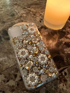 a cell phone case sitting on top of a marble table next to a glass candle