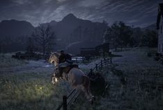 a man riding on the back of a white horse across a lush green field at night