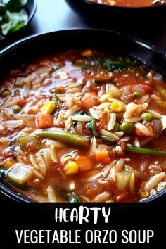 hearty vegetable orzo soup in a black bowl