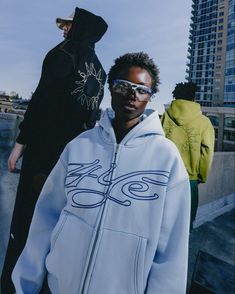 Three models pose wearing the signature logo zip hoodie in matcha, baby blue and black Streetwear Fashion Brand Logo, Campaign Shoot Fashion, Clothing Brand Photography Inspiration, Clothing Brand Campaign, Photoshoot Clothes Ideas, Hoodie Campaign, Photoshoot Clothing Ideas, Hoodies Photoshoot, Streetwear Campaign