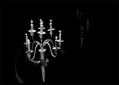 black and white photograph of a man holding a candelabra in the dark