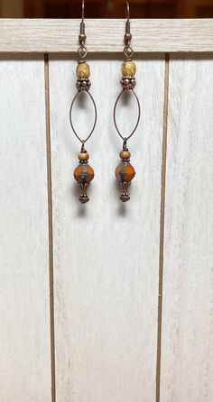 "Looking for long Boho earrings?  These long Boho earrings have a rustic feel to them and were created using orange Czech glass beads with a Picasso finish and a brown wash, tan Czech fire polished beads, copper accents, and oval antique copper connector rings.  Total length of earrings, including the ear wire, is approximately 3\". Thank you for visiting The Lucie Collection!" Bohemian Metal Linear Earrings, Bohemian Metal Linear Earrings With Ear Wire, Bohemian Metal Linear Earrings For Pierced Ears, Adjustable Copper Beaded Drop Earrings, Brown Metal Beaded Earrings With Ear Wire, Brown Metal Beaded Drop Earrings, Beaded Boho Jewelry, Bohemian Style Jewelry, Rustic Earrings