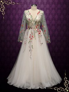 a white dress with red flowers on the front and back, sitting on a mannequin