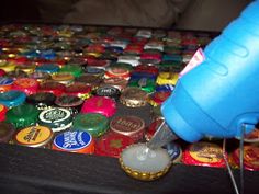 a person is using a bottle opener to press buttons on a table