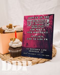 a cupcake with a candle on it sitting in front of a sign that says, join us in the upside down for mine's 11th birthday