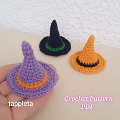 three crocheted witches hats sitting next to each other on a white counter top