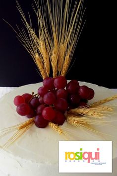 grapes and wheat on top of a white cake