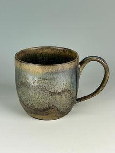 a brown and black cup sitting on top of a table