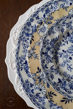 three blue and white plates sitting on top of a wooden table