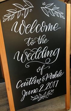 a chalkboard sign with the words welcome to the wedding