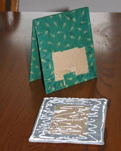 two pieces of paper sitting on top of a wooden table next to a piece of cloth