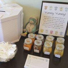 there is a table with honey jars and a teddy bear next to the sign that says yummy yummy