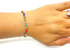 The bracelet is made of round medium sized (4mm) glass eye beads that are multi-colors. They are made with nylon thread and have a woven sliding knot that allows it to fit most wrists. These are a great accessory for any occasion and everyday use. Adjustable Multicolor Evil Eye Bracelet With Tiny Beads, Hand-strung Multicolor Round Friendship Bracelets, Multicolor Hand-strung Round Friendship Bracelets, Adjustable Multicolor Evil Eye Bracelet For Beach, Adjustable Multicolor Beaded Evil Eye Bracelet, Multicolor Beaded Evil Eye Bracelet Spiritual, Multicolor Beaded Evil Eye Bracelet, Adjustable Evil Eye Bracelet With Colorful Beads, Multicolor Beaded Bracelet With Evil Eye