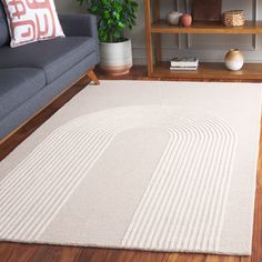 a living room with a gray couch and white rug