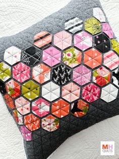 a close up of a patchwork pillow on a bed