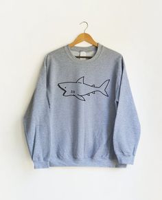 PLEASE NOTE: ALL SHIRTS IN THIS SHOP ARE UNISEX SIZING. REFER TO SIZING CHART AVAILABLE IN IMAGES.+++ CUTE SHARK SWEATSHIRT +++This design is also available as a pocket tee in our shop!--------------For every item purchased we donate $1 to an organization helping establish schools and education infrastructure in developing countries. It's our way of giving back!--------------Available in sizes S-XL in a variety of shirt and text colors.  Please refer to sizing chart for specific measurements.--- Shark Clothes, Shark Sweatshirt, Hipster Art, Shark Shirt, Cute Shark, Hipster Shirts, Cute Graphic Tees, Cute Shirt, Art Fashion