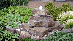 a water fountain in the middle of a garden