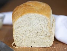 a loaf of bread sitting on top of a wooden cutting board next to a knife