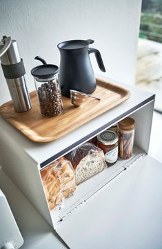 a wooden tray with spices, bread and coffee in it on top of a counter