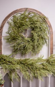 a wreath is hanging on the wall next to a window