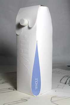 a white carton with a blue water drop on the front and bottom, sitting on top of some drawings