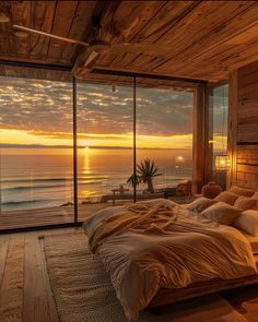 a large bed sitting in a bedroom next to a window with an ocean view at sunset