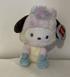 a small stuffed animal with a tag on it's ear sitting on a white surface