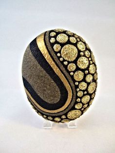 a black and gold decorated egg sitting on top of a white table