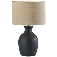 a black table lamp with a beige shade