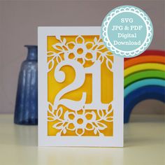 a card with the number 21 on it in front of a rainbow and blue vase