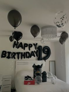 a bedroom decorated with balloons, gifts and a birthday sign that reads happy birthday 19