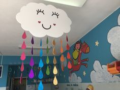 there is a cloud with rain drops hanging from it's ceiling in the children's room