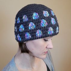 a woman wearing a crocheted hat with elephants on it