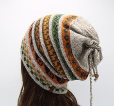 a woman wearing a multicolored knitted beanie hat with tassels