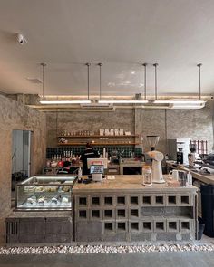 a counter in a restaurant with lots of items on it and lights hanging from the ceiling