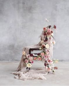 a chair with flowers on it sitting in front of a wall