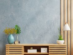 a wooden shelf with two vases on top of it next to a wall mounted clock