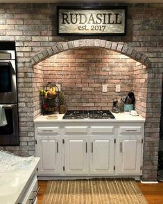 a kitchen with brick walls and white cabinets