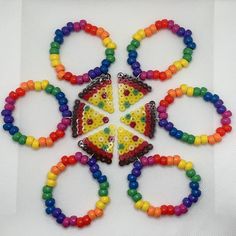 a group of bracelets with different colored beads on them and a piece of pizza in the middle