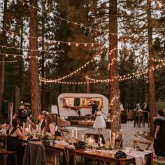 a group of people sitting around a table in the woods