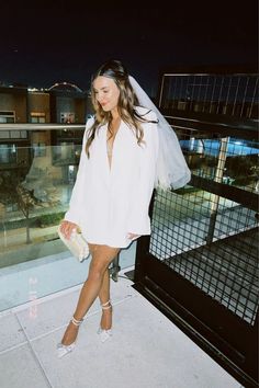 a woman standing on top of a balcony next to a fence