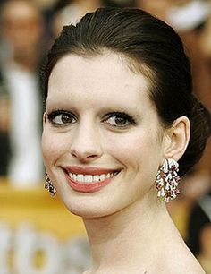 the actress is smiling and wearing large earrings