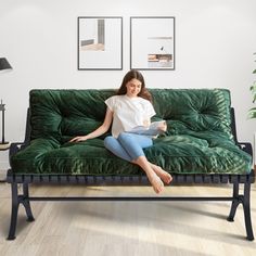 a woman sitting on top of a green couch