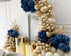 a bunch of balloons that are in the shape of a christmas tree with gold and blue decorations