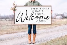 a woman holding a sign that says, every family has a story welcome to ours