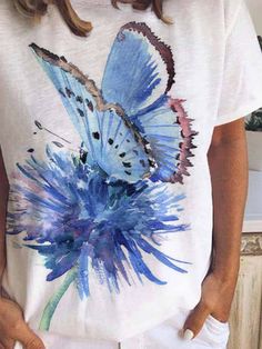 a woman wearing a white t - shirt with a blue butterfly painted on the front