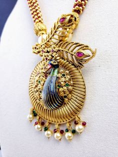 Stunning, unique, OOAK large peacock pendant necklace set, in 3D. Colorful meenakari enamel peacock pendant, with two detailed peacock feathers, sitting in a garden of flowers. Embellished with sparkly ruby red and emerald green crystals. Gorgeous necklace of pearls, gold colored filigree beads, sparkly red crystals, transitioning to tiny seed pearl beads. Wonderful matching earrings with enamel peacocks in 3D and sparkly red crystal floral centers. Dangly pearl and green crystal beads. Pendant Multicolor Peacock Design Temple Jewelry Sets, Multicolor Peacock Design Jewelry Sets For Diwali, Multicolor Peacock Temple Jewelry, Multicolor Peacock Design Temple Jewelry, Multicolor Peacock Design Jewelry For Diwali, Peacock Design Jewelry Sets As Diwali Gifts, Peacock Design Jewelry Sets Gift For Diwali, Peacock Design Jewelry Sets For Diwali Gifts, Diwali Gift Jewelry Sets With Peacock Design